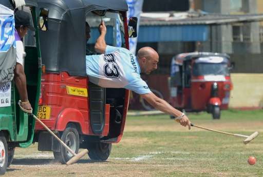 Players take part in a tuk-tuk (three-wheeler) polo match in Galle on February 21, 2016