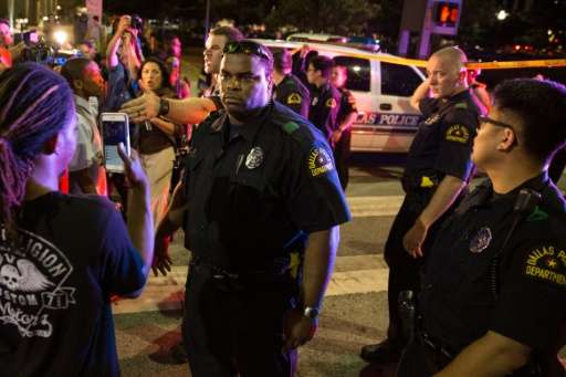 Police attempt to calm the crowd as someone is arrested following the sniper shooting in Dallas on July 7, 2016