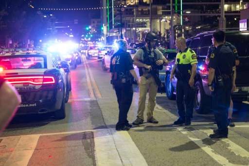 Police stand near a baracade following the sniper shooting in Dallas on Thursday, July 7, 2016