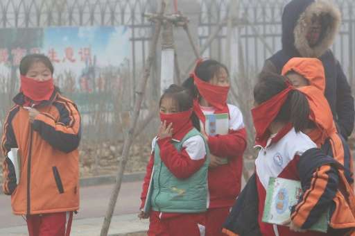 Pupils from an elementary school cover their mouths and noses as they leave the schoolyard after the classes were suspended beca