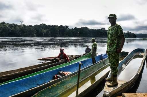 Rangers stop pirogues to check for arms and ammunition, on a stretch of the Ivindo river in the Ivindo National Park, Gabon