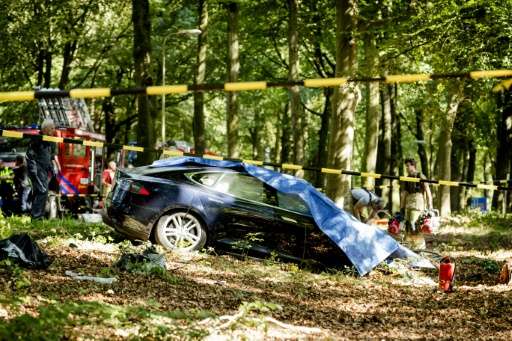 Rescue workers proceed with caution around the spot where a Tesla slammed into a tree in Baarn, on September 7, 2016