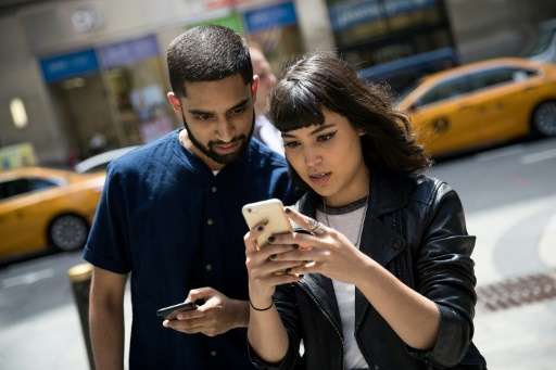 Sameer Uddin and Michelle Macias play Pokemon Go on their smartphones, outside Nintendo's flagship store in New York, on July 11