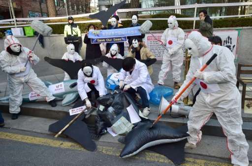 South Korean activists portraying Japanese fishermen spear a &quot;whale&quot; during a protest against Japan's whaling fleet ou