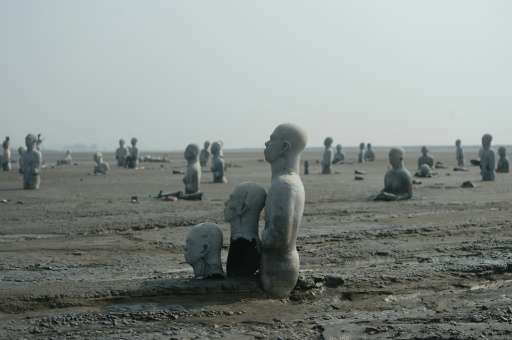Statues stand semi-submerged in mud, a symbol of the human toll of the 2006 mud volcano disaster in Sidoarjo, East Java
