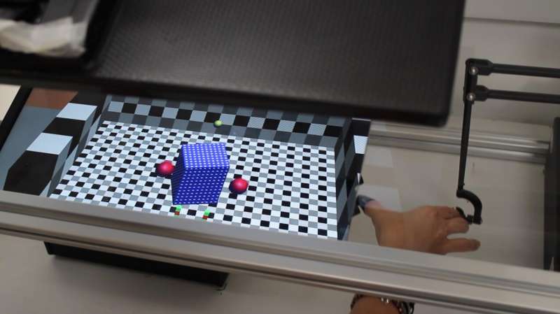 Subject manipulating a cube with hand (right) in a virtual relaity game.