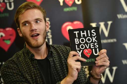 Swedish video game commentator Felix Kjellberg, aka PewDiePie poses with his new book, 'This book loves you' at an event in cent
