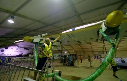 Technicians prepare the solar-powered Solar Impulse 2 aircraft at the Cairo International Airport on July 23, 2016