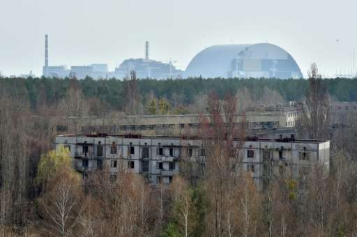 The Chernobyl nuclear power plant is seen in the distance from the ghost city of Prypyat on April 8, 2016