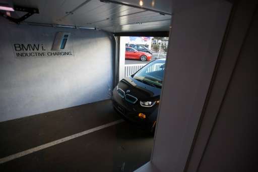 This photo taken on January 8, 2016 shows a BMW i3 electric car as it drives autonomously into a simulated garage to park over a