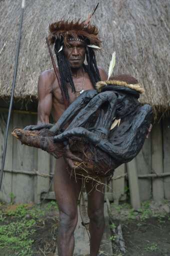Tribe chief Eli Mabel holds the mummified remains of his ancestor, Agat Mamete Mabel, in the village of Wogi in Wamena, the long