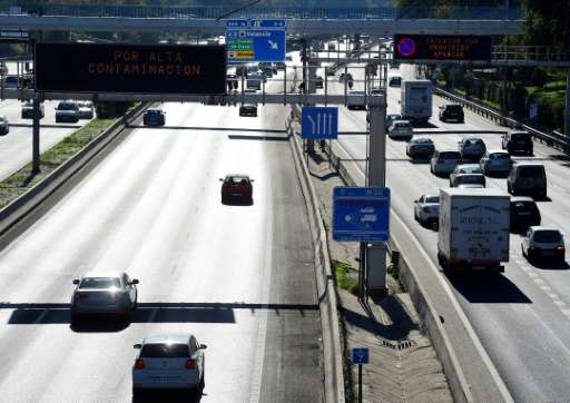 Vehicles on the M30 motorway in Madrid pass under road signs reading speed limitation due to a pollution spike on November 13, 2