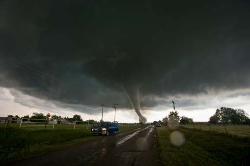 Vehicles stop on the side of a road as a tornado rips through a residential area south of Wynnewood, Oklahoma on May 9, 2016