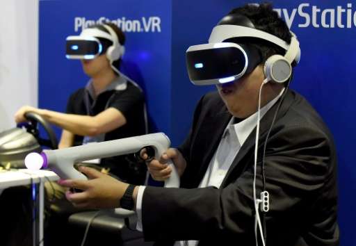 Visitors play a virtual reality game at Sony's booth during the Tokyo Game Show 2016, in Chiba, suburban Tokyo