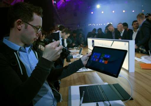 Visitors take pictures of a Matebook during Chinese company Huawei's presentation on the eve of the official opening of the Mobi