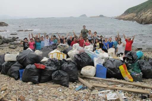 Volunteers pose with all the rubbish collected and bagged for removal at a beach in Hong Kong