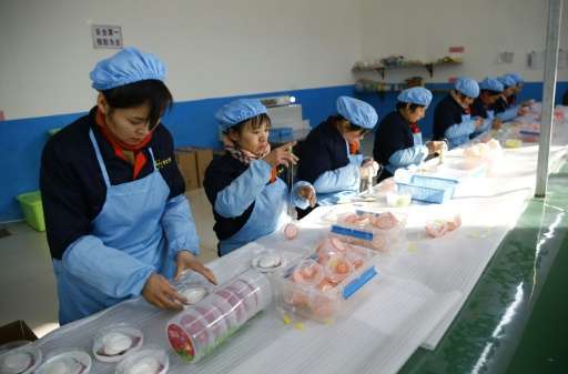 Women work on a pollution mask assembly line at the ASL Masks factory in Dongliu, China's Shandong province