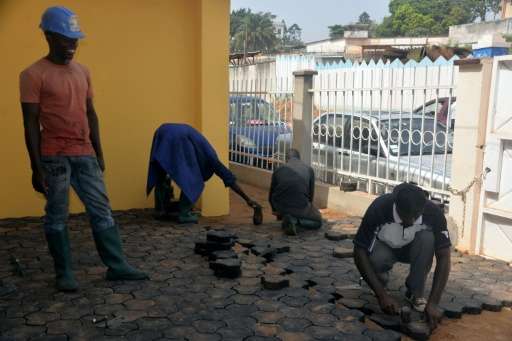 Workers pave the ground with recycled cobblestones made of plastic waste, in Yaounde, Cameroon