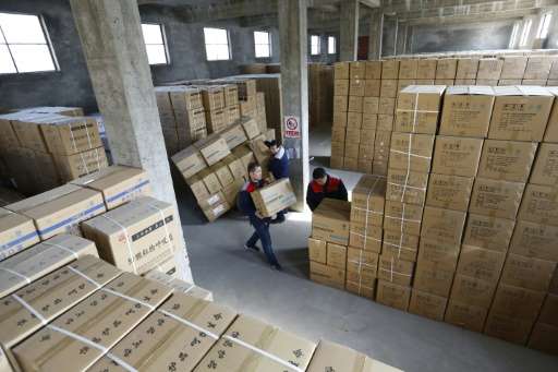 Workers stack boxes of pollution masks at the ASL Masks factory in Dongliu, China's Shandong province