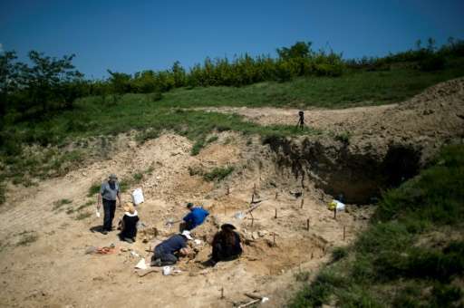 Palaeontologists work near the site in Bulgaria where a fossilised tooth with three roots was found, which some researchers say 