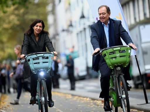 Paris Mayor Anne Hidalgo (L), who is on an crusade to clean up the city's air, aims to lure more Parisians into the saddle