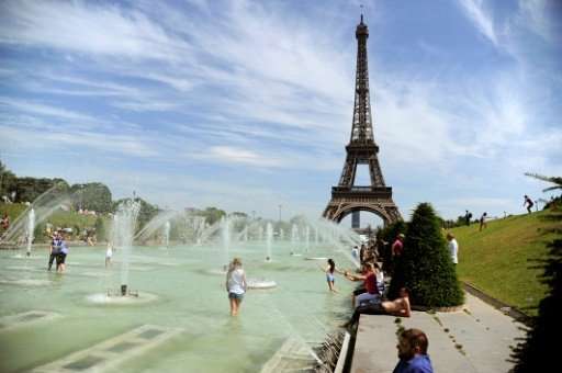 People refresh themselves in the fountain of the Trocadero Gardens by the Eiffel Tower during a June 2015 heatwave in Paris, whe