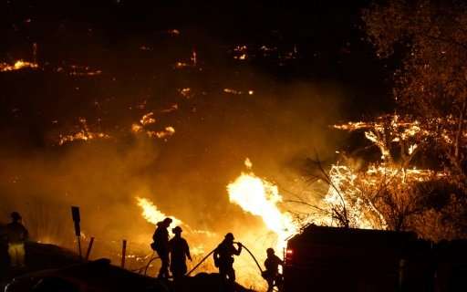 Firefighters battle the Lilac fire in Bonsall, California on December 7, 2017