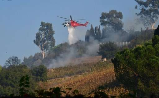 A helicopter drops water over the Moraga Estate, the only working winery in Bel-Air and home to Rupert Murdoch in Bel-Air