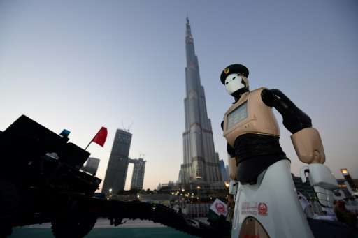 The world's first operational police robot stands to attention in front of Dubai's Burj Khalifa, the tallest tower in the world,