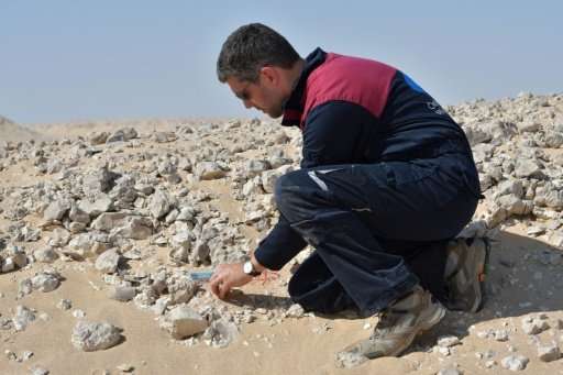 A member of the Austrian Space Forum inspects a site in Oman's Dhofar desert, near the southern Marmul outpost, on October 29, 2
