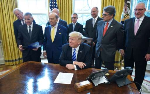 US President Donald Trump smiles after announcing the final approval of the XL Pipline in the Oval Office of the White House on 