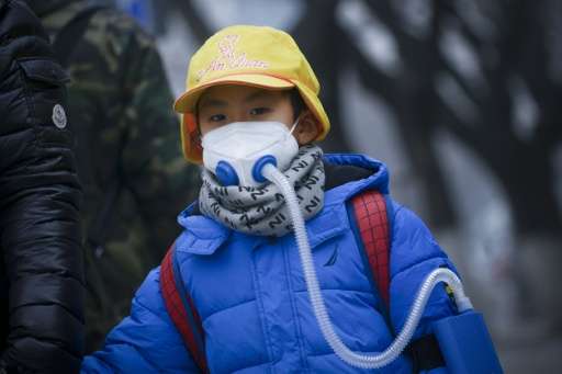 A boy wears an oxygen mask as he walks along a road in Beijing on January 5, 2017