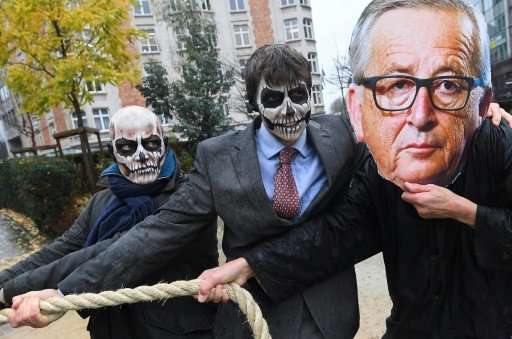 Activists acting as European Commission President Jean-Claude Juncker (R) and Monsanto-characters with their faces painted with 