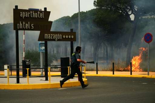 A Guardia Civil officer battling a wildfire near Mazagon in southwestern Spain, which has forced more than 2,000 people to evacu