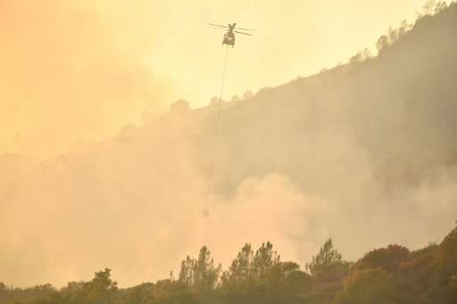 A helicopter drops water on flames in Calistoga, California