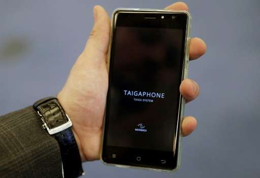 A man holds a TaigaPhone, a brand new smartphone created by InfoWatch Group, during a presentation in Moscow on September 22, 20