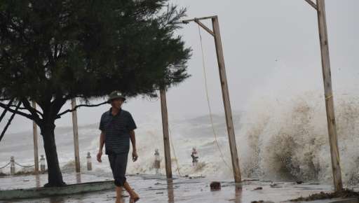 A man looks at waves from a beach in Dien Chau district, central province of Nghe An as the typhoon Doksuri prepares to make a l