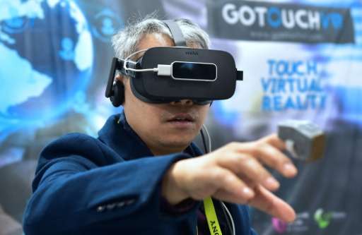 A man tries out the VR Touch, a wearable haptic ring creating the illusion of touching virtual objects, at the 2017 Consumer Ele