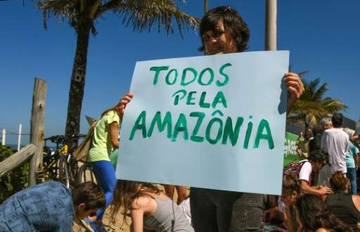 An activist holds a sign that reads &quot;All for the Amazon&quot; during a demonstration by Greenpeace against the Brazilian go