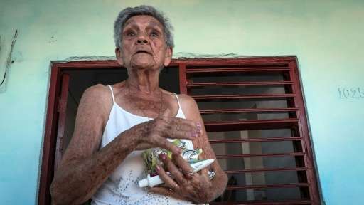 An elderly Cuban woman carries belongings to protect them from the arrival of Hurricane Irma, in Caibarien