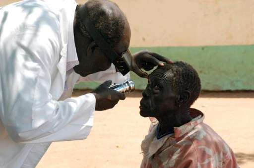 An eye specialist checks the eyes of an elderly patient in Juba