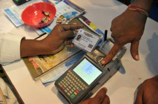 An Indian uses a fingerprint to withdraw money from his bank account with his Aadhaar card