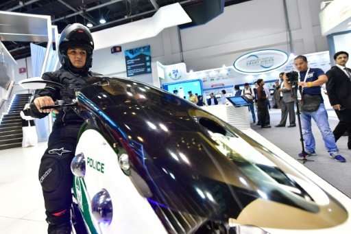 An police officer shows off a high-tech motorbike at the GITEX 2017 exhibition at the Dubai World Trade Center on October 8, 201