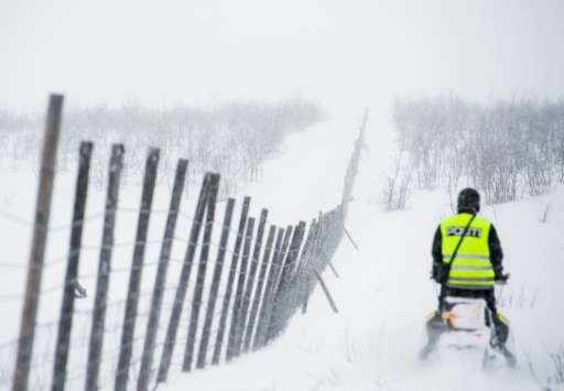 A reindeer police officer rides his snow scooter as he patrols in Finnmark county in northeastern Norway