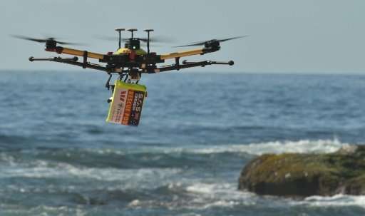 A shark-spotting drone with safety flotation device attached flies over Bilgola beach, Sydney