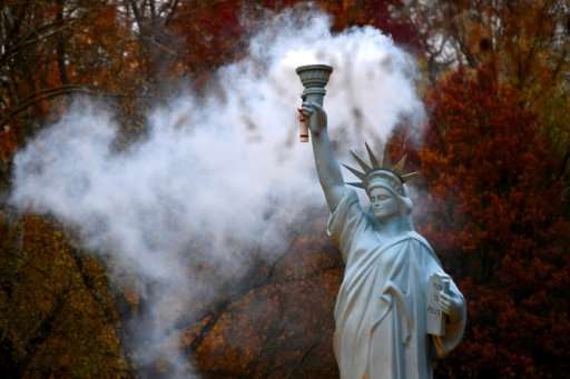 A smoking replica of the Statue of Liberty by Danish artist Jens Galschiot at a park in Bonn during UN climate talks, slowed dow