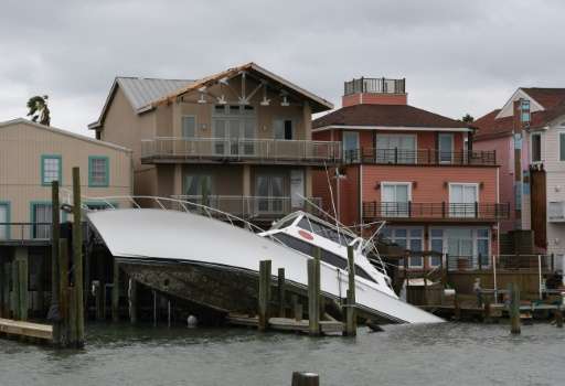 A sunken boat lies submerged in front of houses after Hurricane Harvey hit Port Aransas, Texas