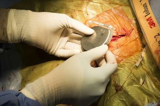 A surgeon implants a pacemaker to a patient