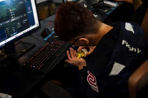 A Taiwanese gamer from the eSports team Flash Wolves takes Vitamin B pills during training for the League of Legends World Champ
