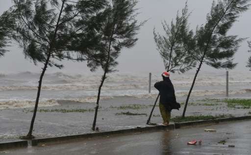 A woman looks at waves at a beach in Dien Chau district, central province of Nghe An as the typhoon Doksuri prepares to make a l